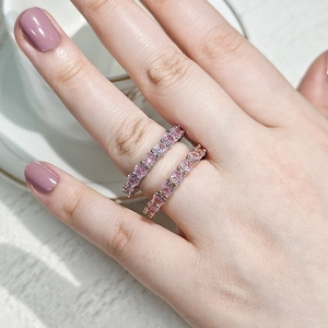 Detail of stacked eternity rings featuring pink cubic zirconia in silver and rose gold