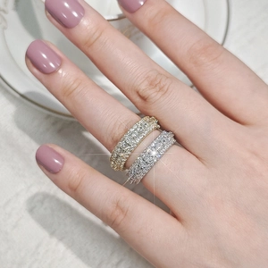 Close-up of gold and silver stackable zircon eternity rings on a model's hand