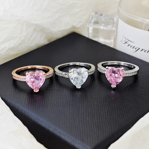 Detailed view of heart-shaped gemstone rings with pavé diamond bands in three colors