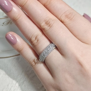 Close-up of triple row pavé setting zircon ring on finger for elegant styling