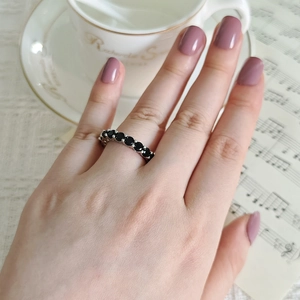 Macro shot of silver ring with pave-set black zircons worn in elegant lifestyle setting