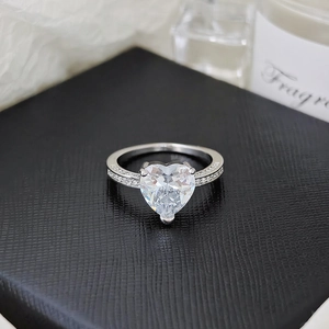 Close-up of heart-shaped diamond ring in silver setting inside a black jewelry box