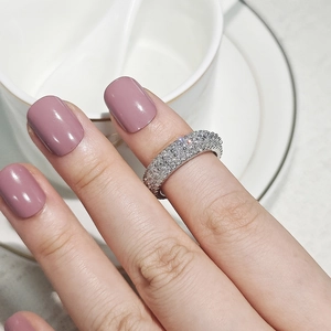 Close-up of a stacked cubic zirconia eternity ring on a model's finger in a lifestyle setting