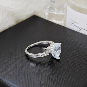 Detailed close-up of a silver heart-shaped diamond ring on a premium black jewelry box