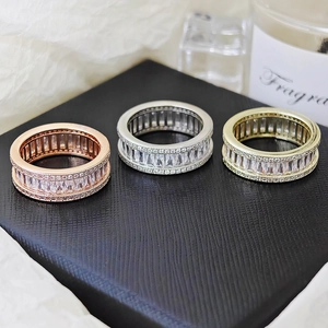 Detailed macro view of three hip-hop style rings with full rectangular and round zircons