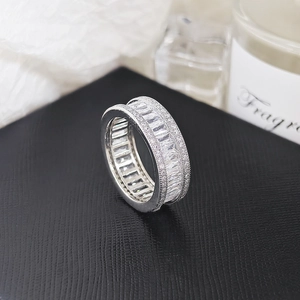 Macro shot of rectangular-cut zircons and pavé setting on a polished silver eternity ring