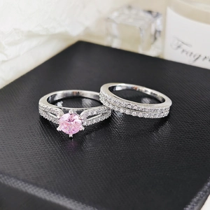 Close-up of pink gemstone engagement ring and pavé diamond band set on jewelry box
