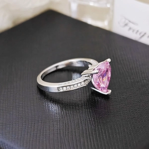 Macro shot of pink heart-shaped gemstone ring with silver band and micro-pave diamonds