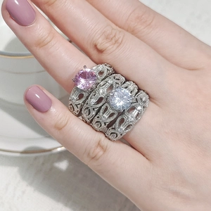 Dettaglio di anelli impilabili vintage in argento con gemme rosa e bianche