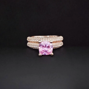 Macro shot of rose gold rings with a large square pink gemstone and white pavé zircons