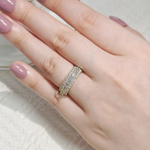 Close-up of gold plated pavé eternity ring with rows of sparkling zircon stones on finger