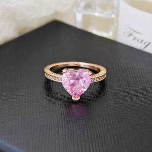 Detail of a pink heart-shaped crystal ring in rose gold with pave diamond accents