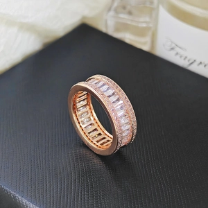 Macro shot of rose gold wide band ring with pave set rectangular and round zircons