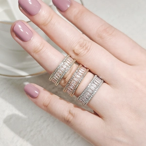 Close-up of three baguette-cut diamond stackable rings in gold, rose gold and silver