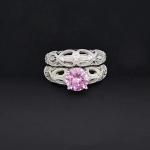 Dettaglio del set di anelli vintage in argento con gemma rosa e decori milgrain