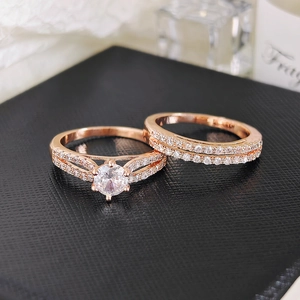 Close-up of rose gold wedding ring set with brilliant round-cut main stone and pave band