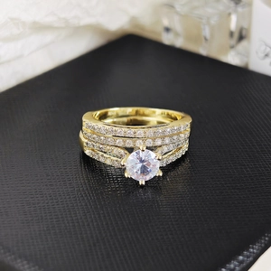 Macro shot of three-piece gold ring set with a large round diamond and micro-pave stones