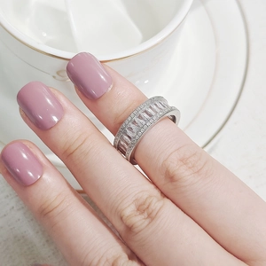 Close-up of silver baguette-cut and pavé-set diamond ring on a hand with manicure