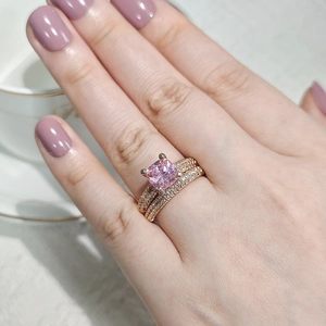 Close-up of rose gold ring set with pink cushion-cut gem and micro-pave white diamonds