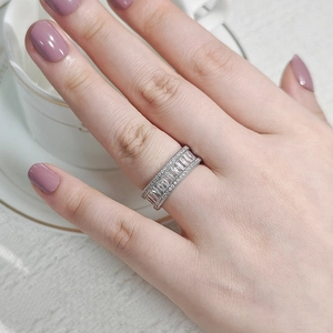 Close-up of minimalist silver ring with square and round zircons worn by a hand
