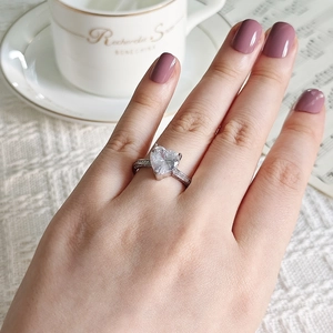 Detail shot of heart-shaped zircon ring with pavé small diamonds on a silver band