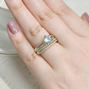 Close-up of a three-piece gold ring set with a large round solitaire and pave diamonds