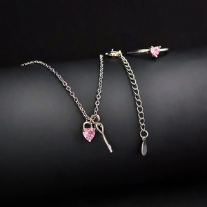 Sieradenset met roze hartvormige edelstenen, zilveren ketting en ring op zwarte basis