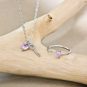 Sieradenset met roze hartkristal, sleutelketting en verstelbare ring op houten standaard