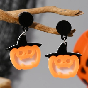 Pendientes de calabaza de Halloween con sombreros de bruja colgados en una rama