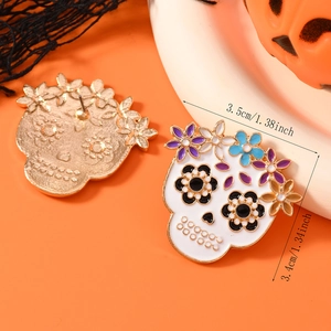 Detail view of sugar skull earrings with floral enamel patterns and 3.5cm dimension markings