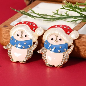 Orecchini a perno con pinguino di Natale in smalto e strass su sfondo rosso festivo