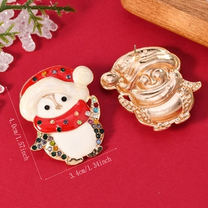 Dettaglio degli orecchini a pinguino natalizi con strass e smalto multicolore