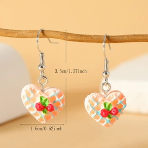 Detail van hartvormige wafel oorbellen met rode kers en productafmetingen