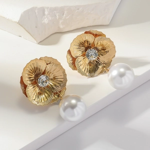 Detail of gold floral drop earrings with sparkling center stones and large white pearls
