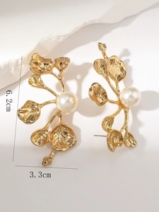Vue détaillée des boucles d'oreilles feuilles d'or vintage avec perles et texture martelée