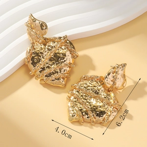 Detailed size view of irregular gold leaf earrings with hammered texture and chain detail
