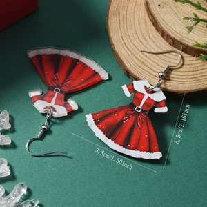 Vue détaillée des boucles d'oreilles robe de Noël en acrylique sur fond festif