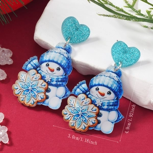 Détail de boucles d'oreilles bonhomme de neige en acrylique avec cœurs pailletés