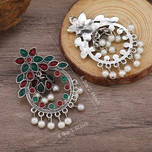 Dettaglio di orecchini boho con perline colorate e design in filigrana metallica