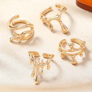 Ensemble de quatre bagues dorées style métal liquide avec un design de lave polie