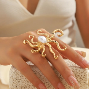 Détail d'une bague poulpe dorée avec grande perle baroque blanche et yeux en pierres noires