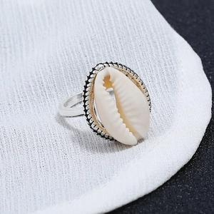 Gros plan d'une bague bohème en argent avec coquillage naturel et texture gravée rétro