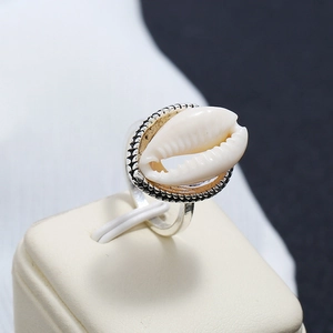 Vue macro d'une bague argentée avec coquillage ovale et détails de bordure torsadée