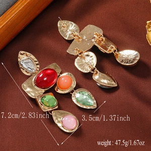 Detail of vintage geometric earrings with colorful gemstones and textured gold base