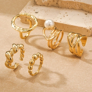 Detail eines 5-teiligen vergoldeten Ring-Sets mit Perlen und gedrehter Textur