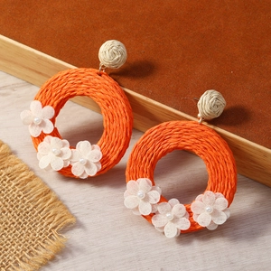 Orecchini boho in rafia arancione fatti a mano con fiori di stoffa bianca e perle