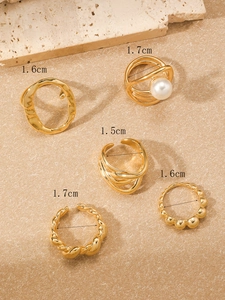 Detailansicht eines 5-teiligen goldenen Ring-Sets mit Perlen und gedrehten Strukturen