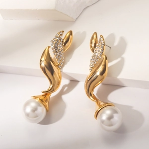 Macro detail of vintage gold twist earrings with sparkling rhinestones and white pearls