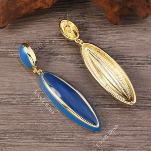 Macro view of vintage gold dangling earrings with deep blue resin and size dimensions