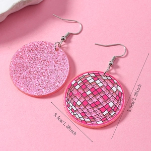 Dettaglio di orecchini retrò con paillettes rosa e motivi a scacchi in acrilico